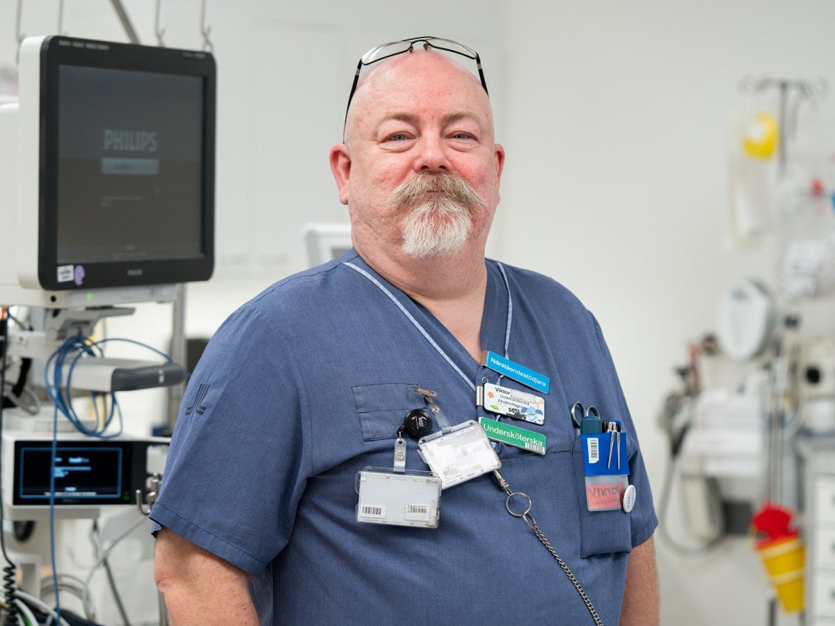 man i sjukhuskläder i ett sjukhusrum