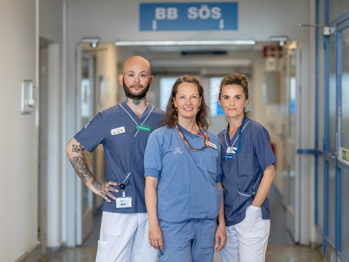 tre medarbetare tillsammans framför skylt till BB Sös