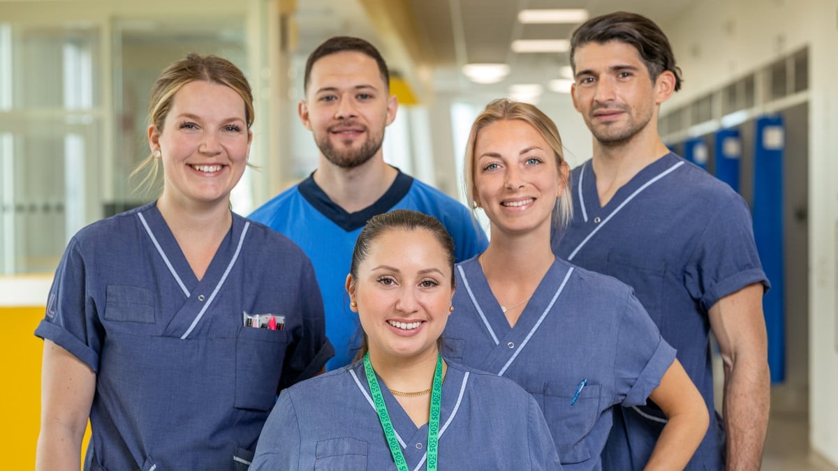 gruppbild fem medarbetare i sjukhusmiljö